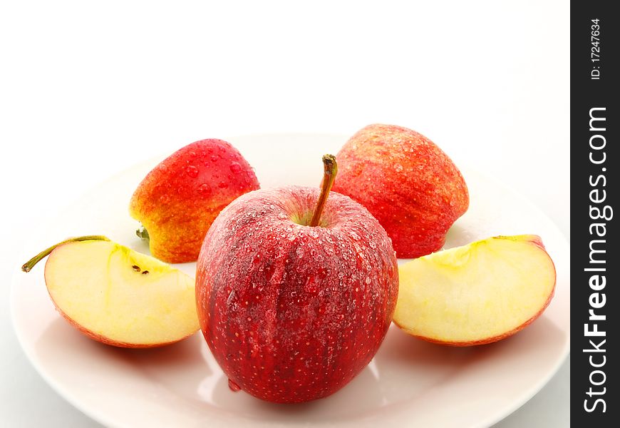 Red apples on white plate towards white background