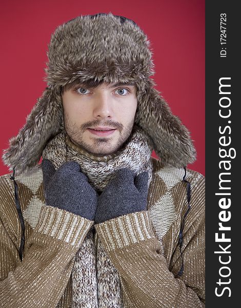 Young man in winter clothes over red background. Young man in winter clothes over red background