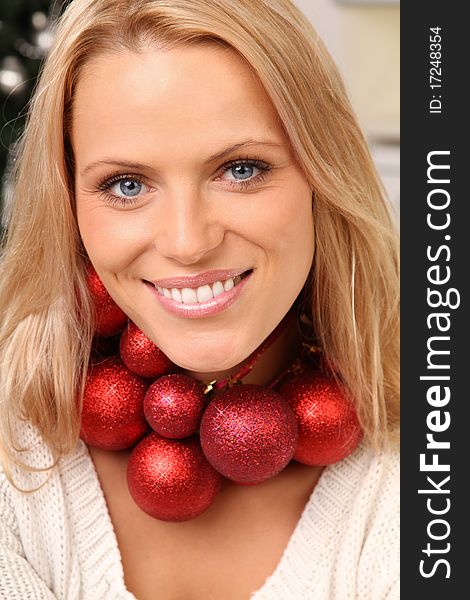 blond woman wearing some christmas balls as a chain. blond woman wearing some christmas balls as a chain