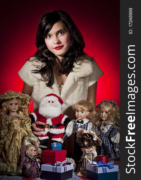 Young female with her dolls and santa claus receiving christmas gifts. Young female with her dolls and santa claus receiving christmas gifts