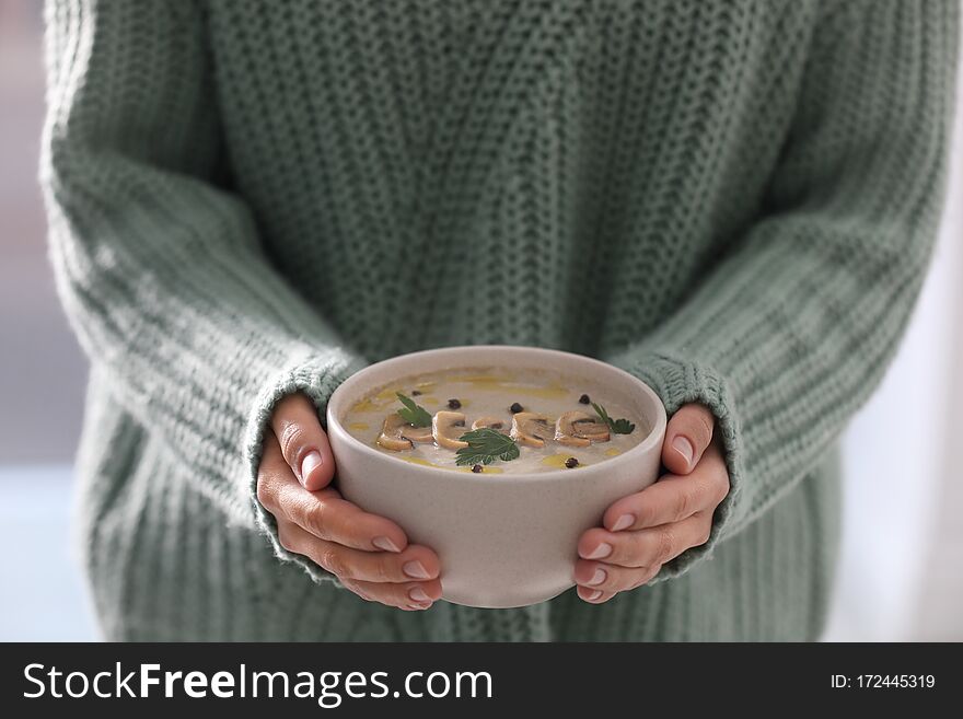 Young woman with bowl of cream soup