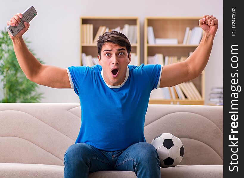 Man Watching Football At Home Sitting In Couch