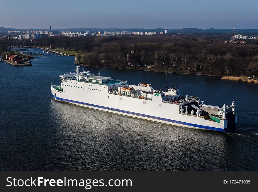 The passenger ship flows through the port channel to the terminal. The passenger ship flows through the port channel to the terminal