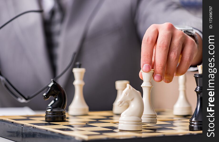 Young businessman playing chess in the office