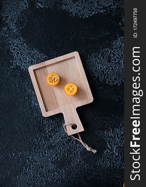 Kumquat On A Black Background On A Wooden Board, Wood