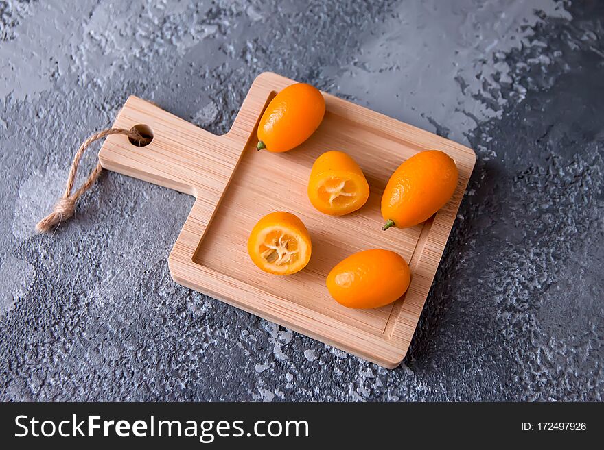 Fruit kumquat against a grey concrete background