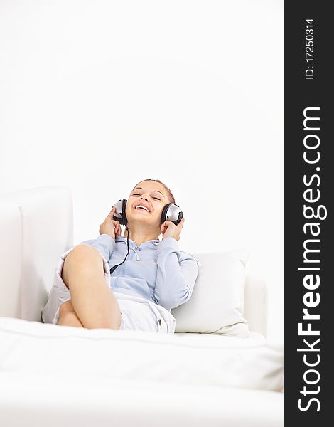 Young woman sitting on couch and listen to the music