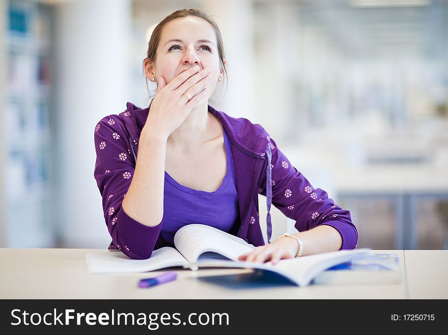 Pretty female college student in a library