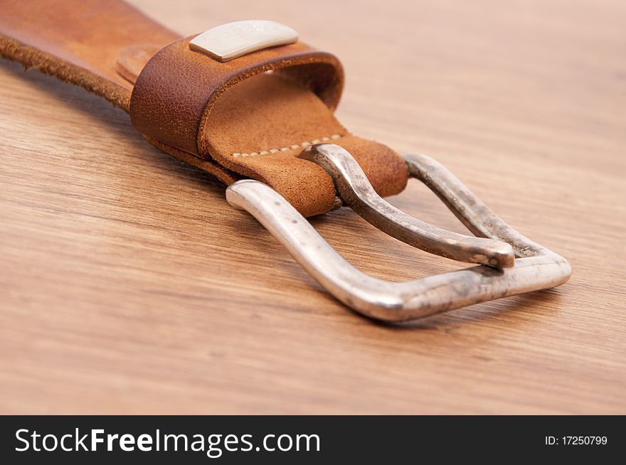 Belt of natural skin on a wooden