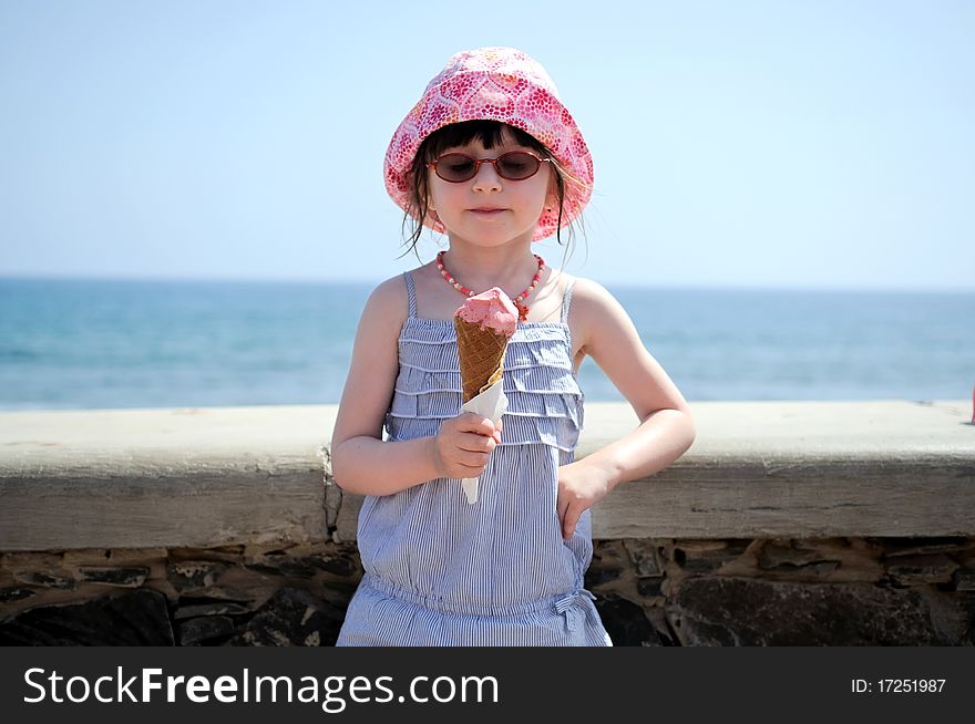 Small girl in glasess and sun hat on vacation with ice cream. Small girl in glasess and sun hat on vacation with ice cream