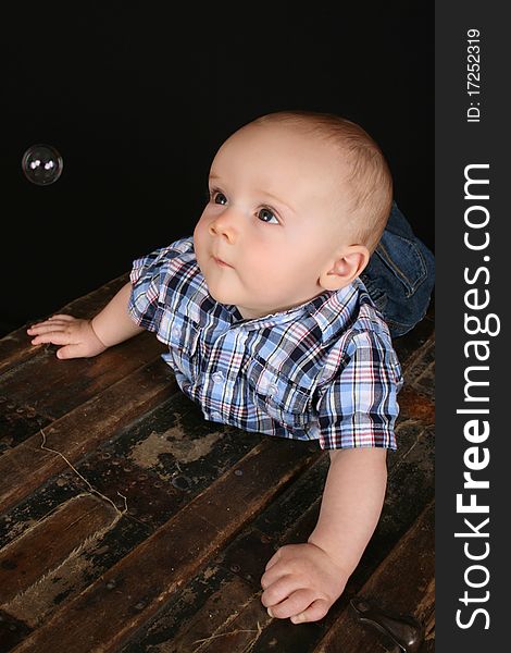 Cute little boy on an antique trunk wearing blue jeans. Cute little boy on an antique trunk wearing blue jeans