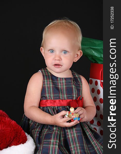 Cute blond toddler holding a christmas decoration in her hands. Cute blond toddler holding a christmas decoration in her hands