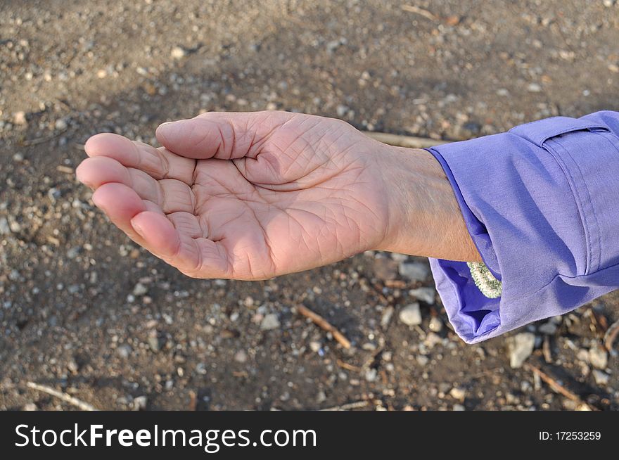 Outstretched hand of an elderly woman begging