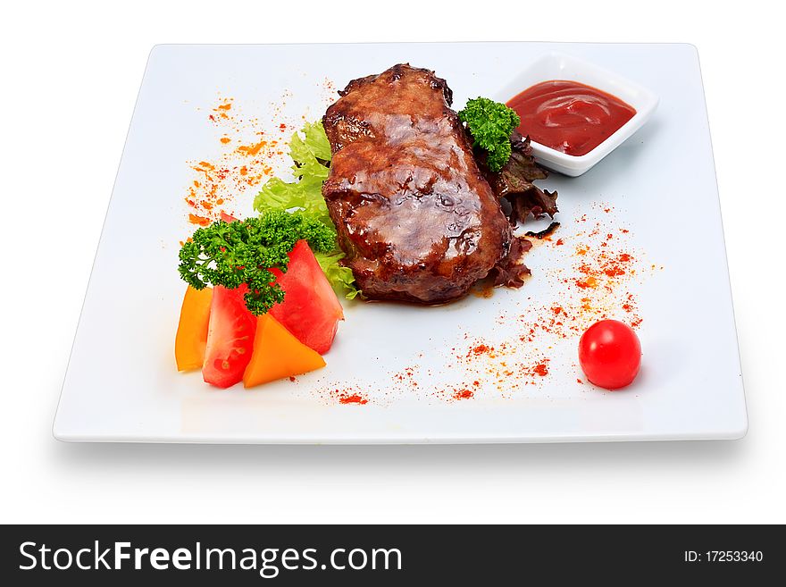 Meat dish steak with vegetables and herbs on a ceramic platter. Meat dish steak with vegetables and herbs on a ceramic platter