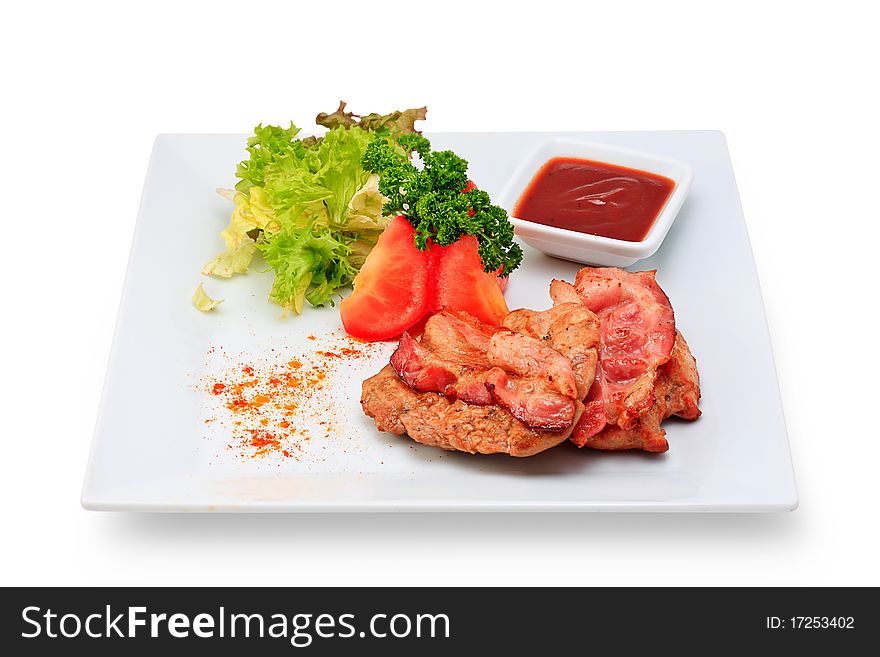 Meat dish steak with vegetables and herbs on a ceramic platter. Meat dish steak with vegetables and herbs on a ceramic platter