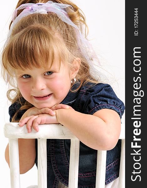 Pretty girl in blue dress sitting white chair