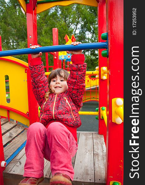 Little girl plays in playground in a park