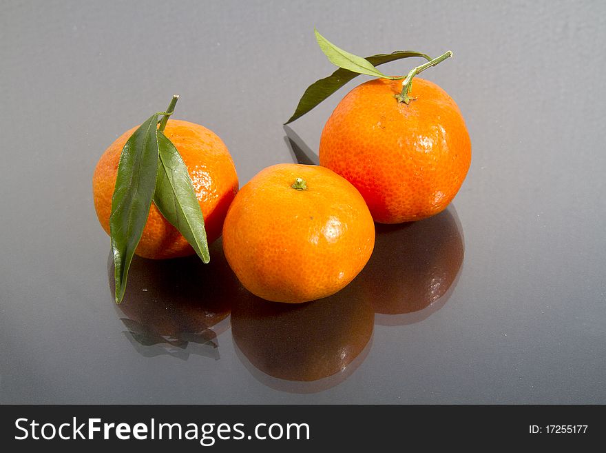 Mandarin oranges isolated on black gloss. Mandarin oranges isolated on black gloss