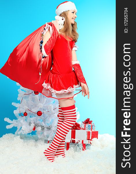 Beautiful young woman in Santa Claus clothes over Christmas background.