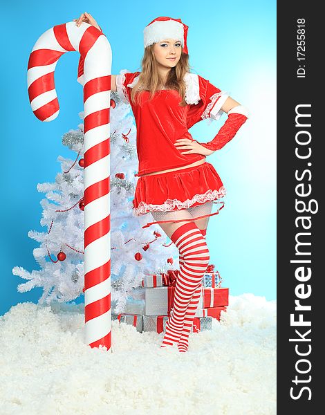 Beautiful young woman in Santa Claus clothes over Christmas background. Beautiful young woman in Santa Claus clothes over Christmas background.