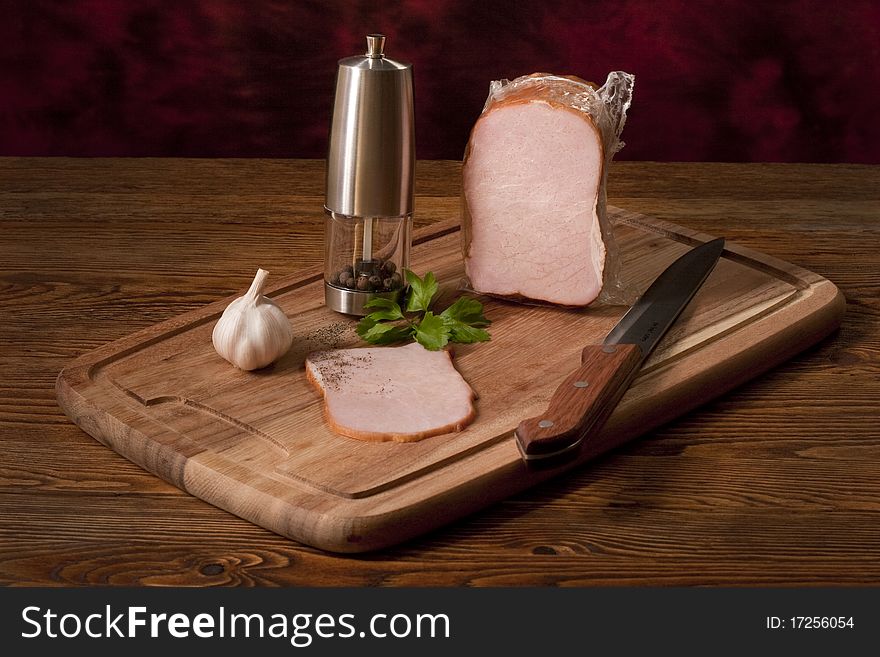 Composition with smoked vacuum packed ham on the table. Composition with smoked vacuum packed ham on the table