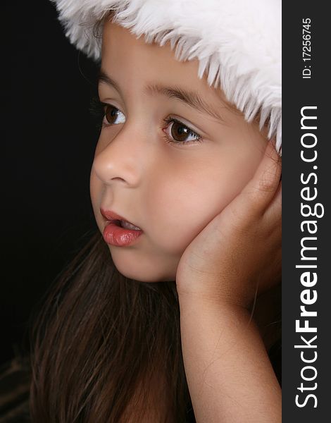 Cute little brunette girl wearing a christmas hat. Cute little brunette girl wearing a christmas hat