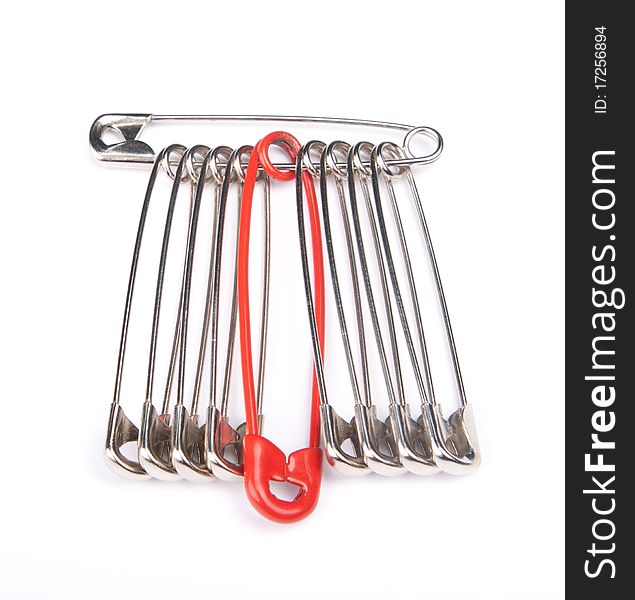 Safety pins in a row with one distinguishing red pin. Safety pins in a row with one distinguishing red pin