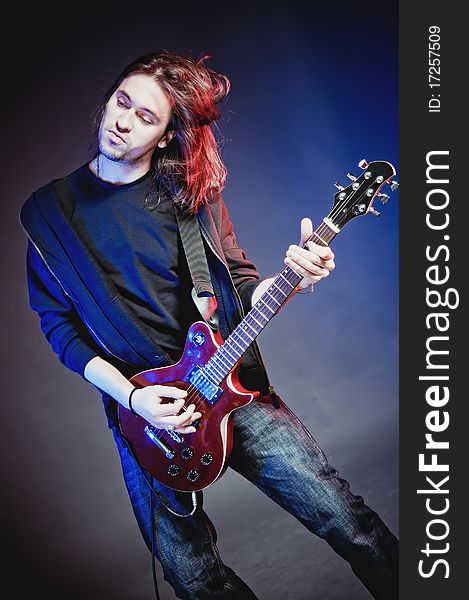 Rock-star perfoming loud music on red electric guitar. Rock-star perfoming loud music on red electric guitar