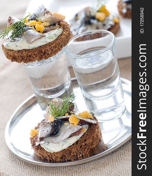 Anchovy canapes garnished with dill and yolk and vodka. Anchovy canapes garnished with dill and yolk and vodka