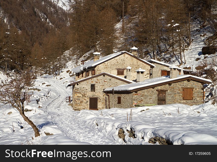 Cabins in a mountain valley in the North of Italy during winter. Valle delle Messi, Brixia province, Lombardy region, Italy. Cabins in a mountain valley in the North of Italy during winter. Valle delle Messi, Brixia province, Lombardy region, Italy