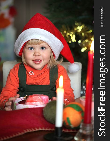 Small girl with gift christmas box and candle