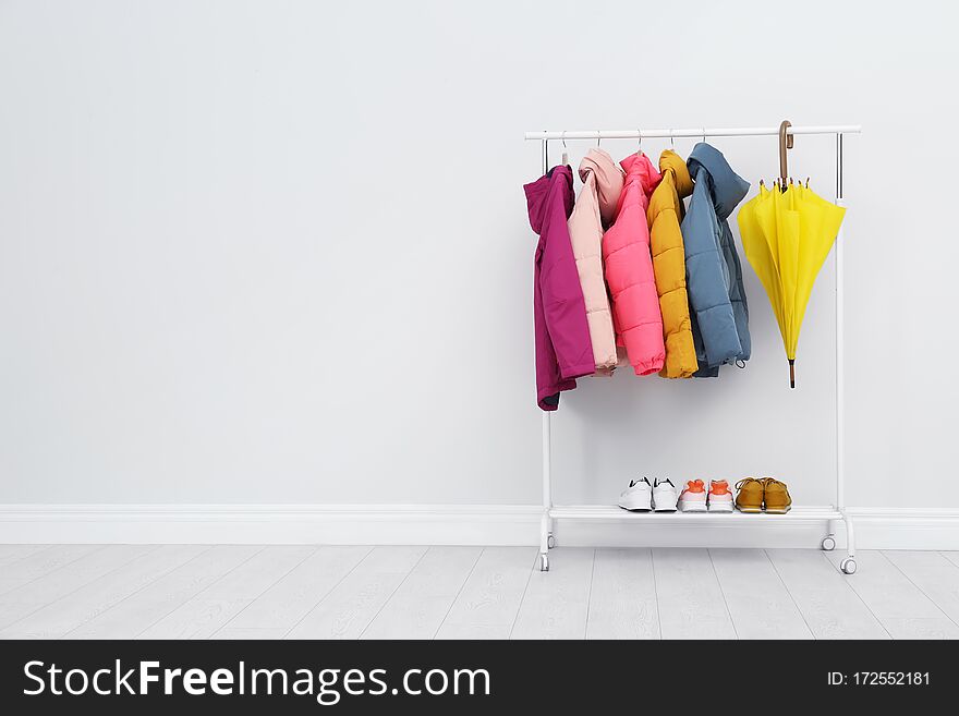 Rack with warm jackets in room. Space for text