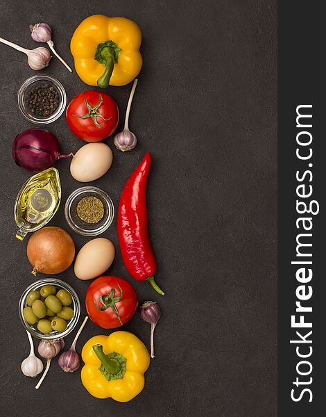 Set of vegetables for a healthy diet, yellow and red peppers, tomatoes onions garlic eggs olives rocket,  spinach.  Healthy food fitness. Flat lay, black background. Copy space