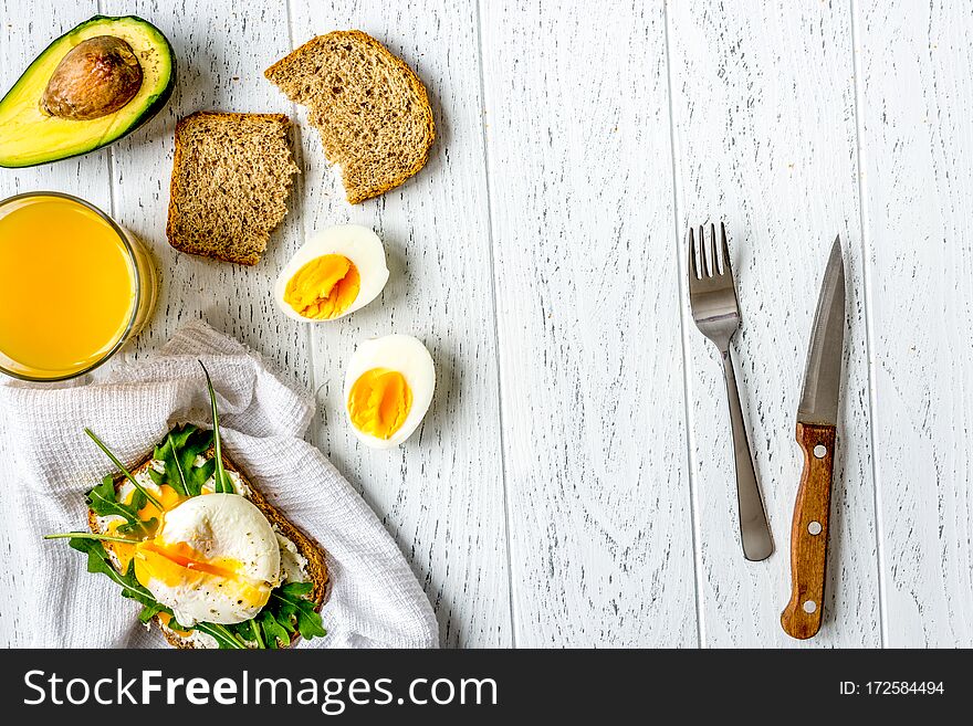 Sandwich with poached eggs on wooden background top view mockup.