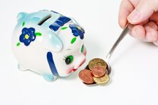 Male Hand Feeding A Piggy Bank With A Coins Royalty Free Stock Photos