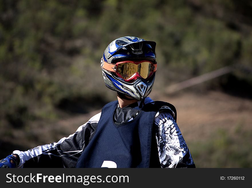 Close view of a motocross rider with helmet.