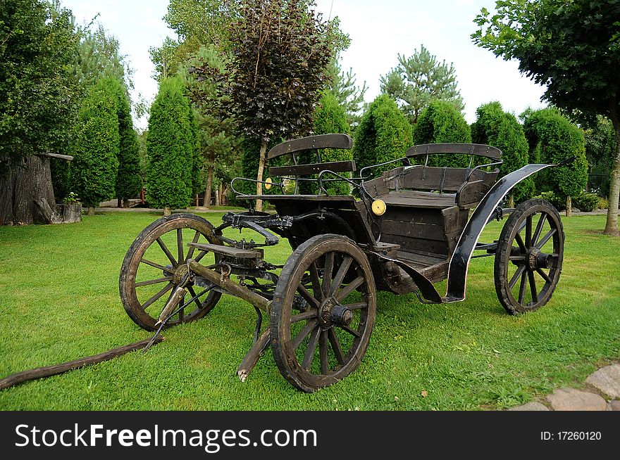 Old horse-drawn carriage on a green grass