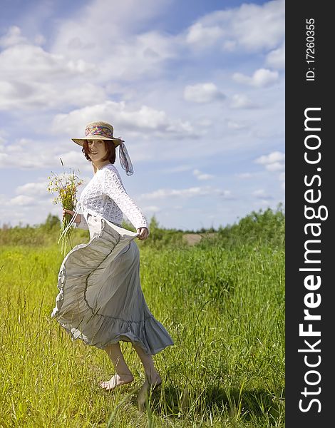 Barefooted young woman running in the field. Barefooted young woman running in the field
