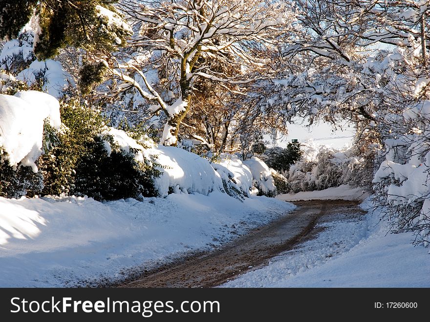 A horizontal image of a snow covered road in winter. A horizontal image of a snow covered road in winter