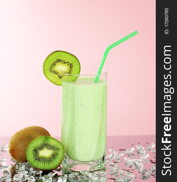 Kiwi juice in a glass on a pink background