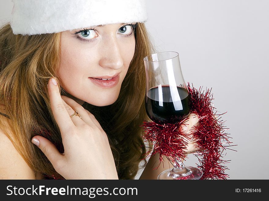 Girl in a Christmas hat drinking wine