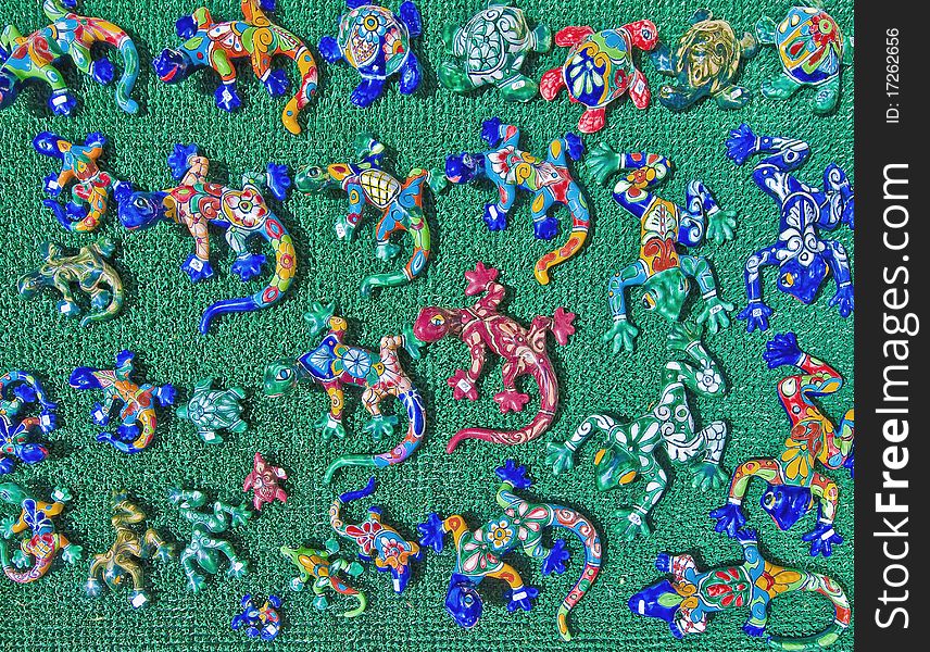 Colorful ceramic lizards over a green background