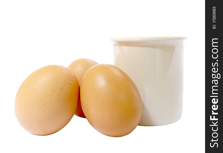 Three eggs leaning against a white pot. Three eggs leaning against a white pot