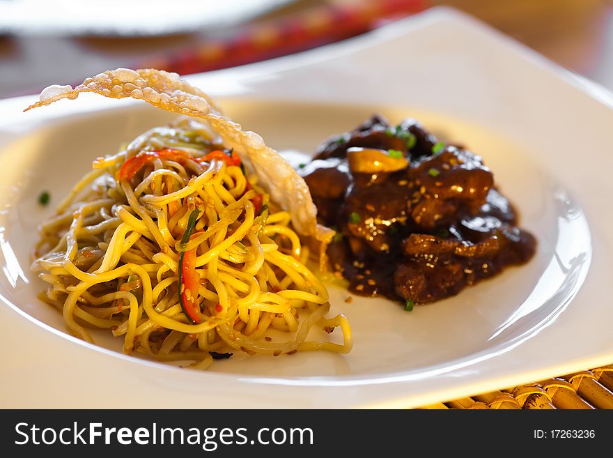 Dish of asian noodles green and red peppers. Served with meat. Shallow depth of field