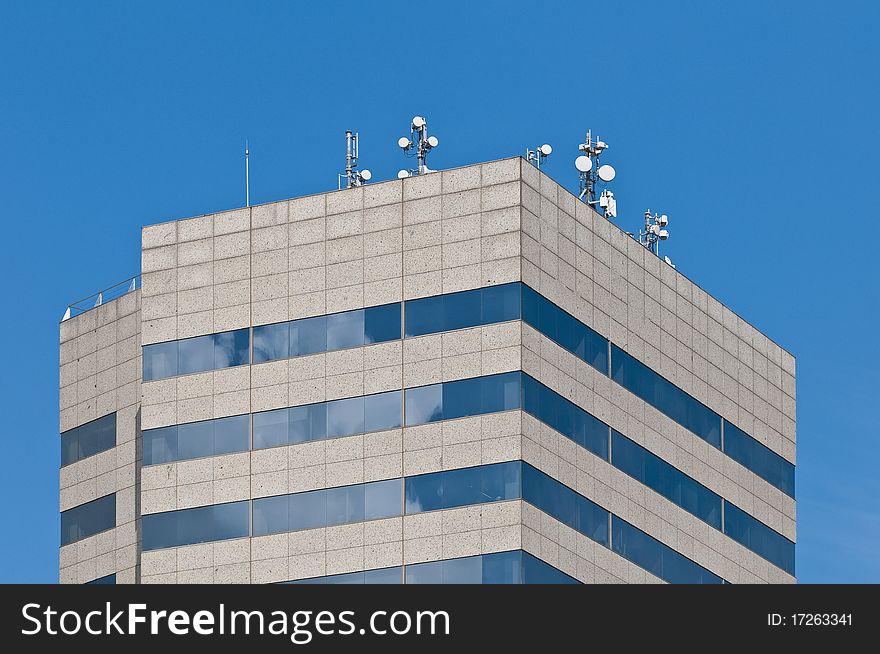 Antennas on a rooftop of a modern building.