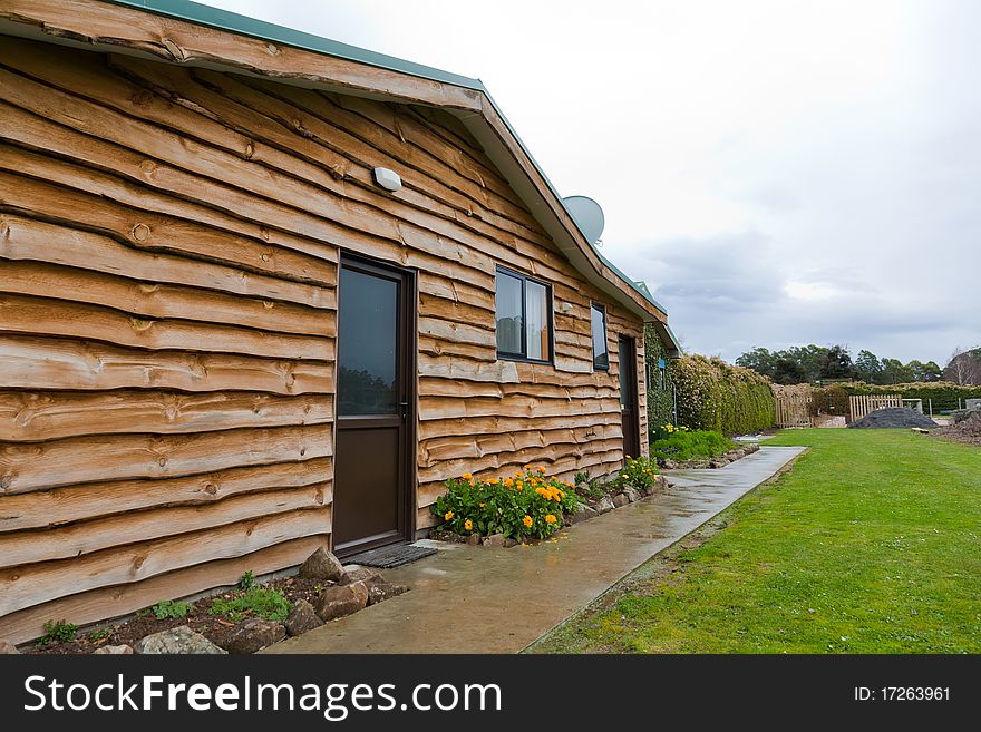 Wide angle view of a pretty log cabin in a rural area, Tasmania. Wide angle view of a pretty log cabin in a rural area, Tasmania.