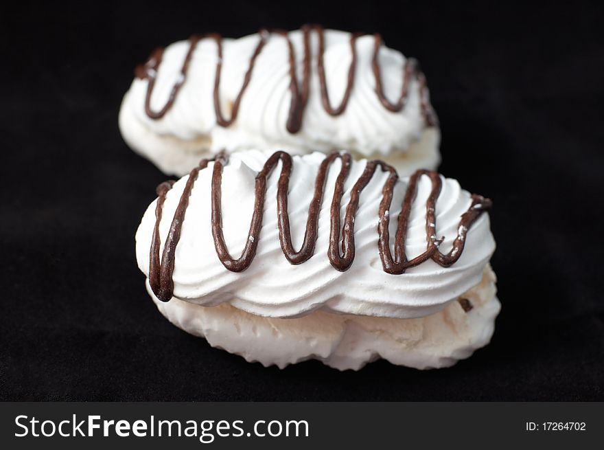 Meringue (Bizet) cake with chocolate on black background