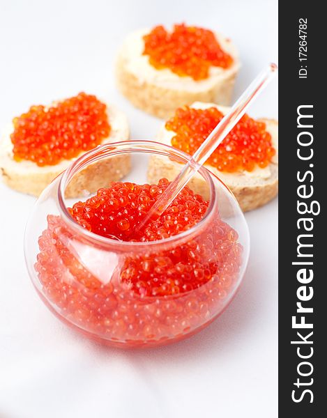 Jar with red caviar and sandwiches