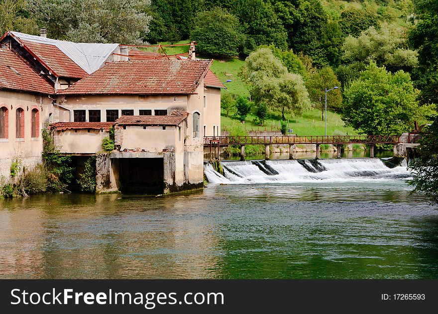 A weir in the river near an old watermill in the neighbourhood of Ornans, le Doubs, France.