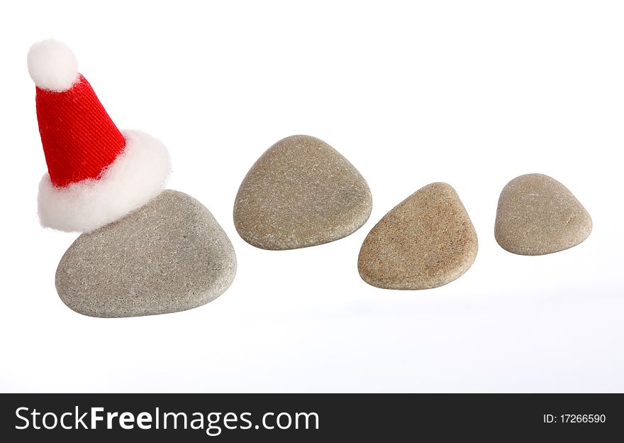 Four small stones with Santas cap isolated on white, copy space, you can write you numbers on stones